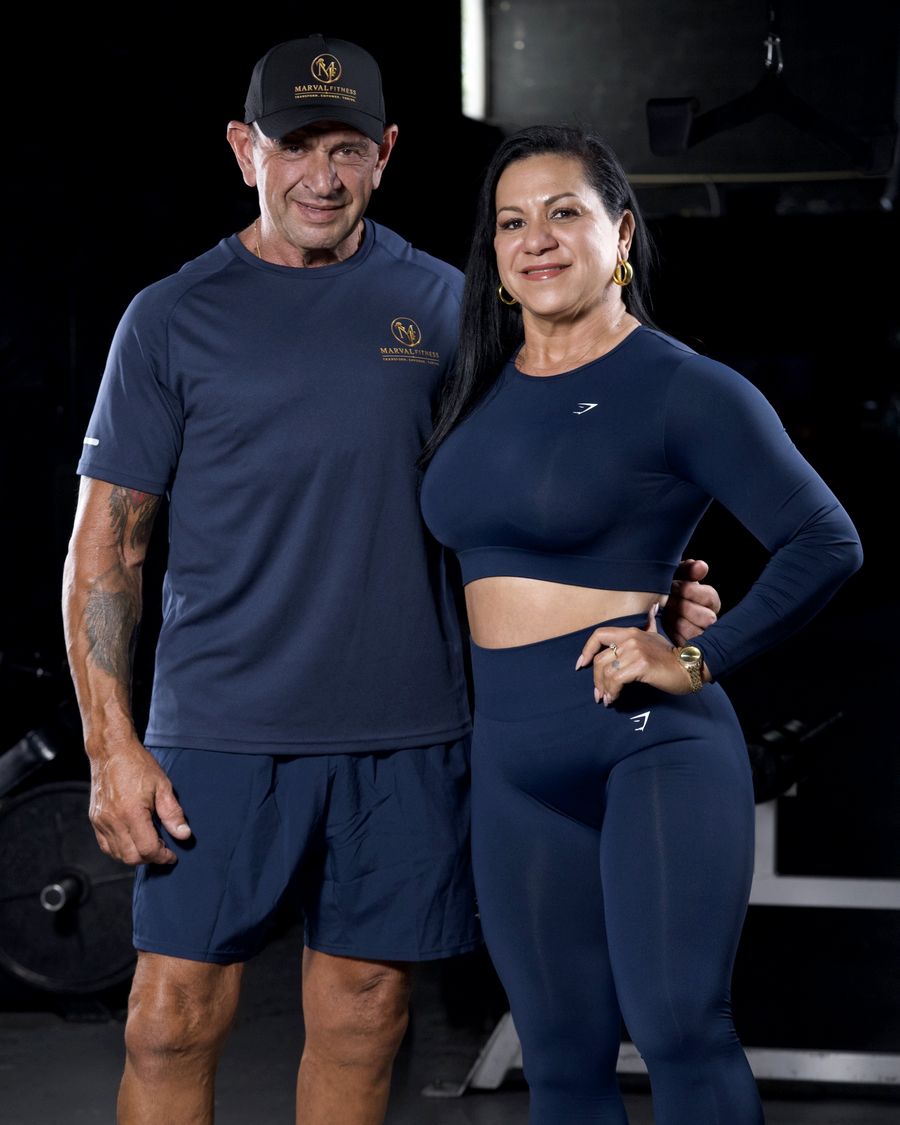 Jorge Gonzalez and Karina Marval standing together in matching navy